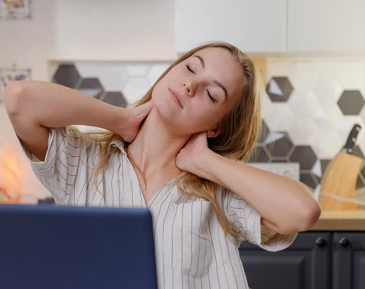 Femme qui s'étire devant L'ordinateur 